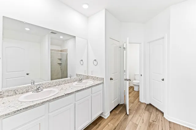a spacious bathroom with a granite countertop sink mirror and shower
