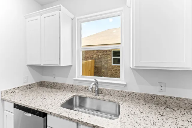 a kitchen with granite countertop a sink and a window