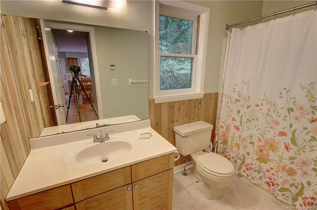 149 Irwin Way Clyde, NC 28721 - Photo 13 of 29 a bathroom with a sink a toilet and shower curtain