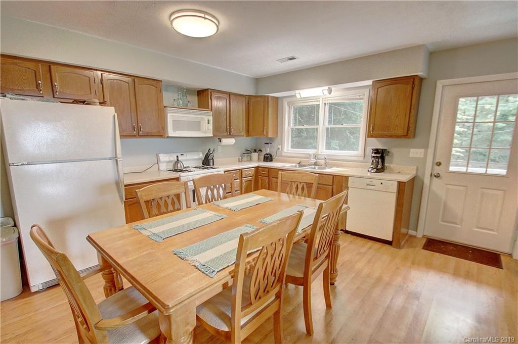 149 Irwin Way Clyde, NC 28721 - Photo 9 of 29 a kitchen with a sink a stove a refrigerator cabinets and dining table