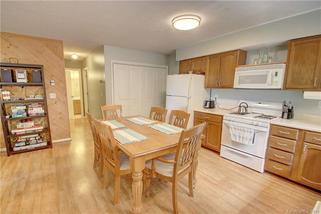 149 Irwin Way Clyde, NC 28721 - Photo 10 of 29 a kitchen with a table chairs refrigerator and cabinets