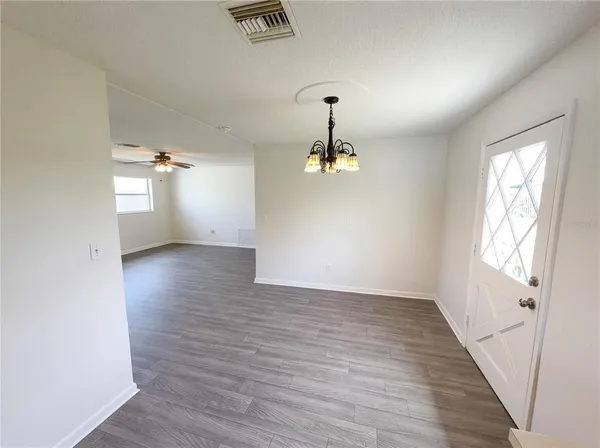 a view of a room with wooden floor and white walls