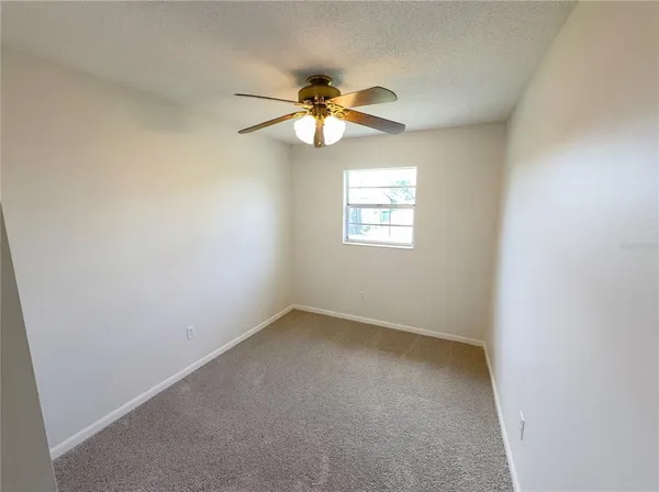 an empty room with a chandelier fan