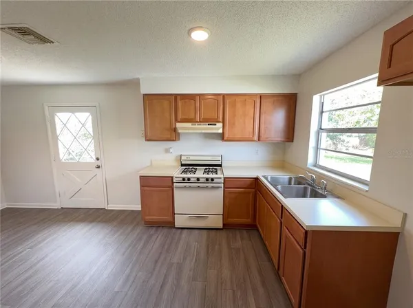 a kitchen with wooden floors and sink