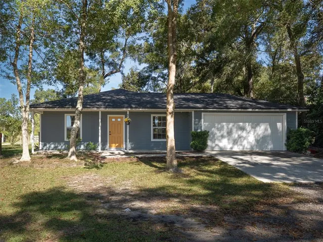 a front view of a house with yard outdoor seating and garage