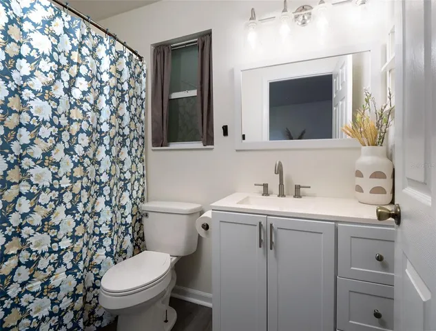 a bathroom with a toilet sink vanity and mirror