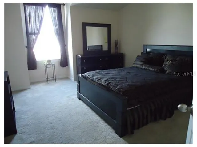 a bed sitting in a bedroom next to a window