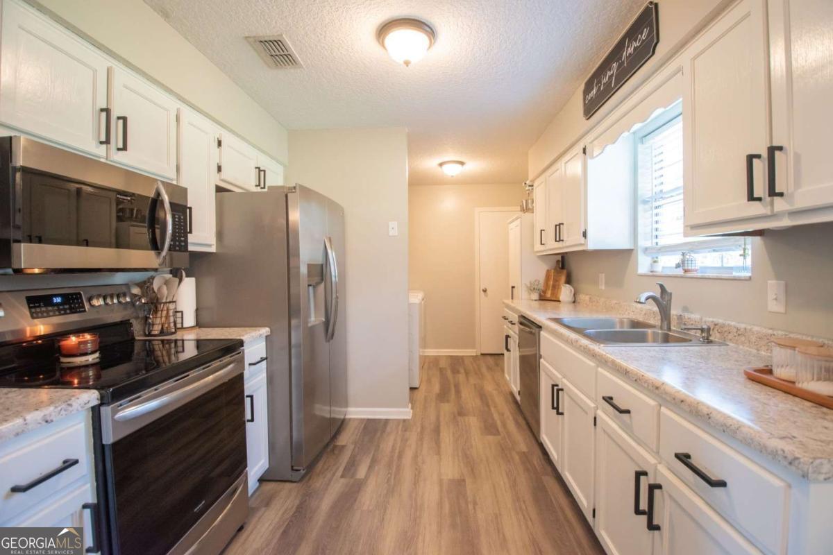 564 Dallas Circle Folkston, GA 31537 - Photo 11 of 21 a kitchen with stainless steel appliances a stove refrigerator sink and microwave