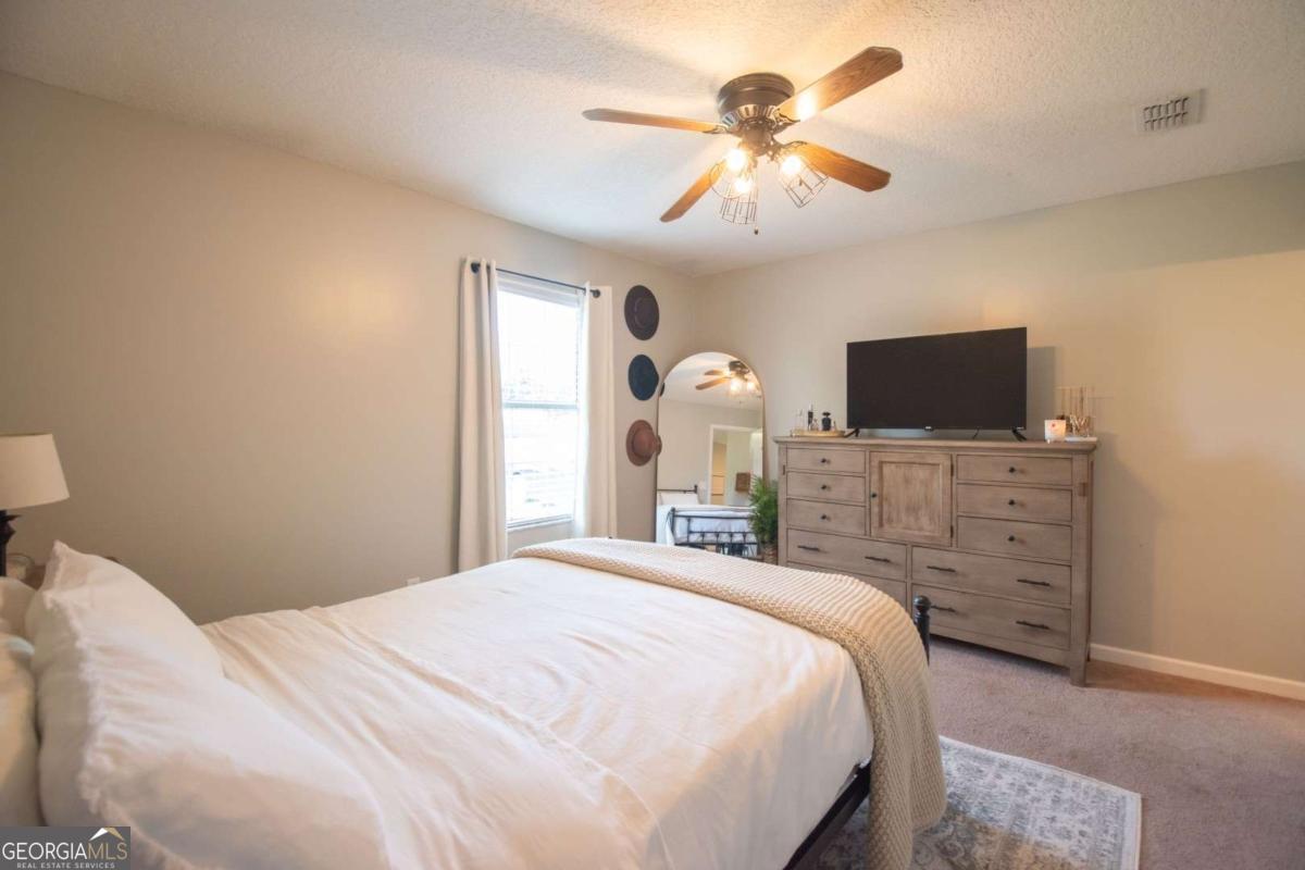 564 Dallas Circle Folkston, GA 31537 - Photo 15 of 21 a bedroom with a bed and a flat screen tv