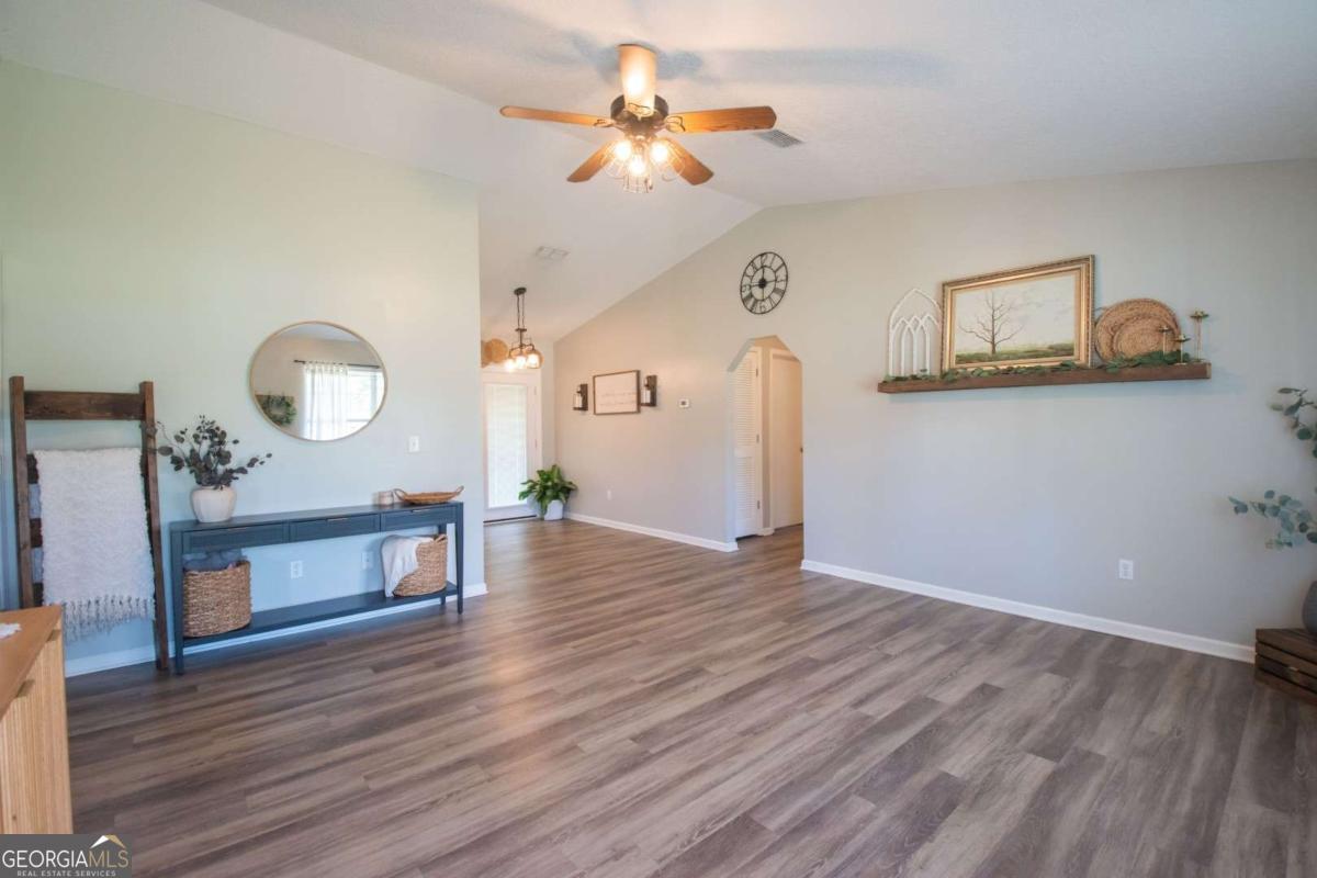 564 Dallas Circle Folkston, GA 31537 - Photo 2 of 21 a view of a workspace room with wooden floor a chandelier fan and wooden floor