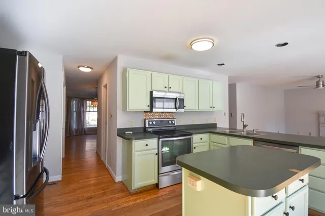 a kitchen with stainless steel appliances granite countertop a sink a stove and refrigerator