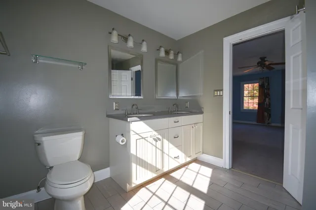 a spacious bathroom with a toilet sink and mirror