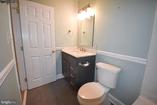 a bathroom with a granite countertop toilet sink and mirror
