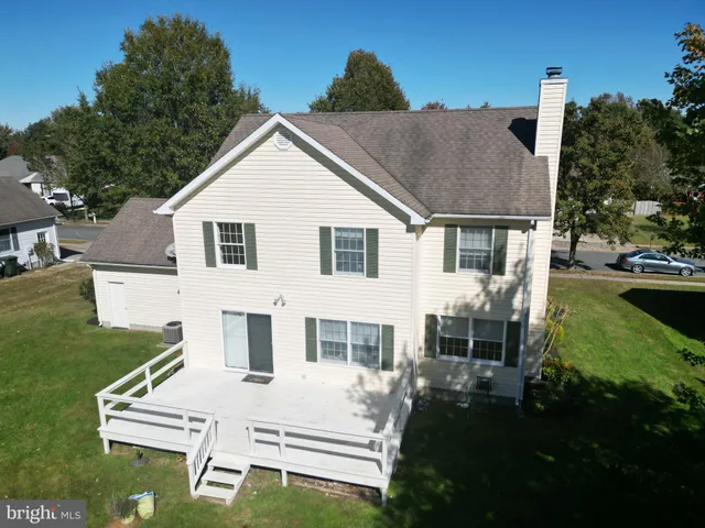 a white house with tall trees in front of it