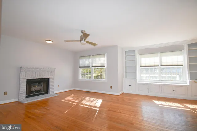 an empty room with windows and fireplace