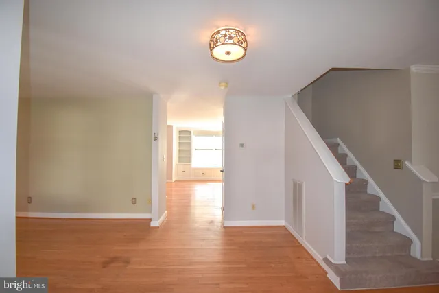 a view of an empty room with stairs and a window