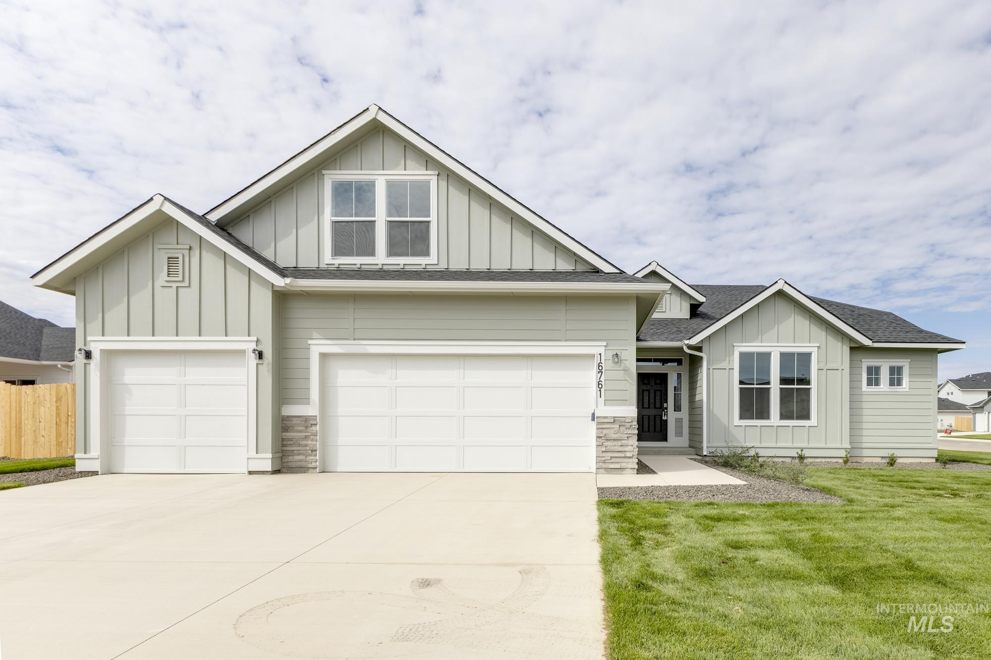 Craftsman-style home featuring board and batten siding, driveway, a shingled roof, and an attached garage