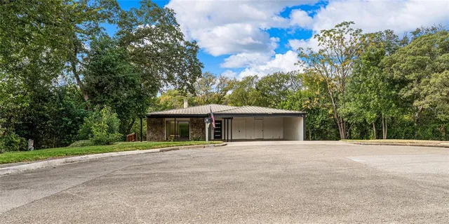 a front view of a house with a yard and trees