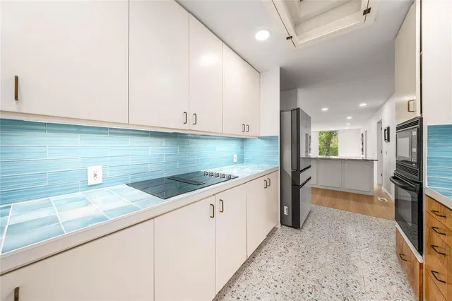 a kitchen with stainless steel appliances granite countertop a sink and a stove