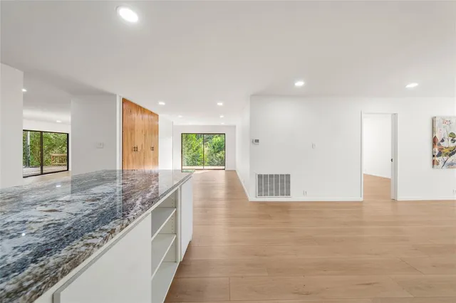 a view of kitchen and kitchen with granite countertop a sink