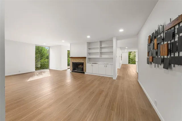 an empty room with wooden floor and a fireplace