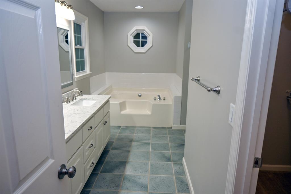 4847 Champion's Way Columbus, GA 31909 - Photo 20 of 39 a bathroom with a granite countertop sink a mirror and a bathtub