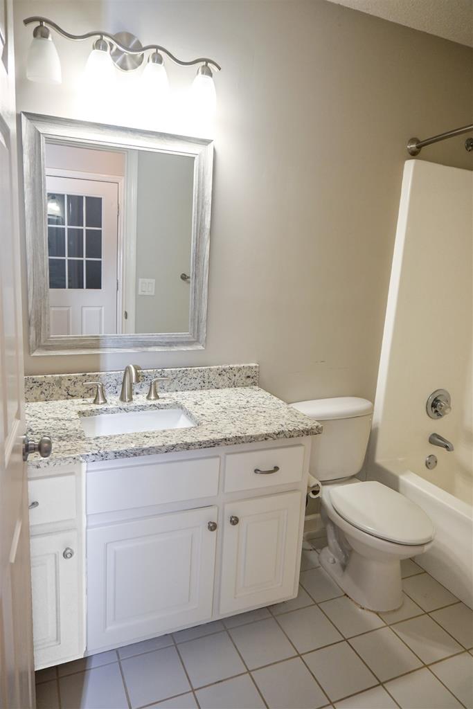 4847 Champion's Way Columbus, GA 31909 - Photo 29 of 39 a bathroom with a granite countertop toilet sink and mirror