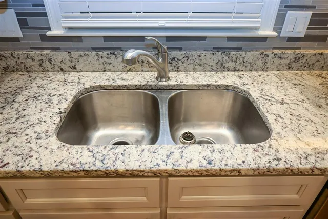 a sink with granite top and granite counter top