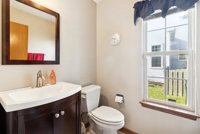 a bathroom with a toilet a sink a vanity and mirror