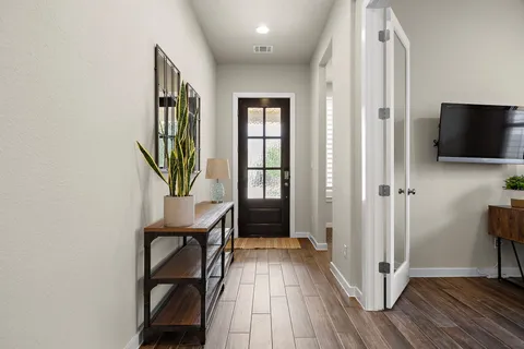 a view of a hallway with entryway wooden floor and front door