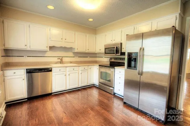 a kitchen with a refrigerator sink and cabinets