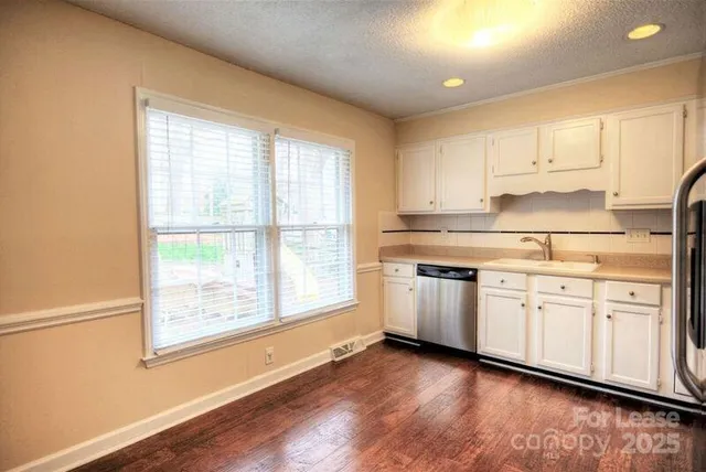 a kitchen with granite countertop white cabinets and white appliances