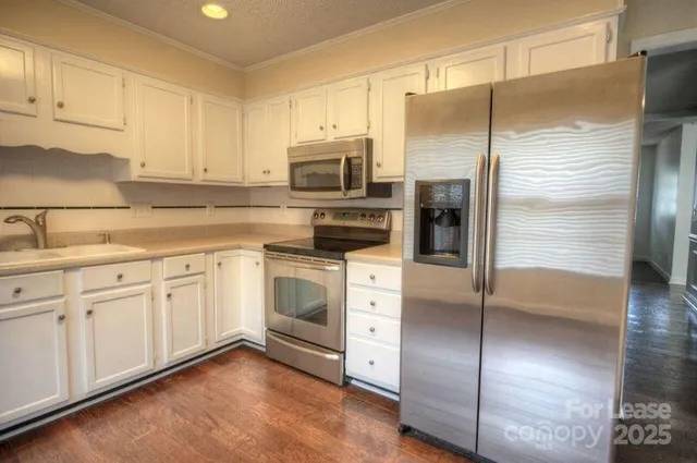 a kitchen with cabinets stainless steel appliances and a window