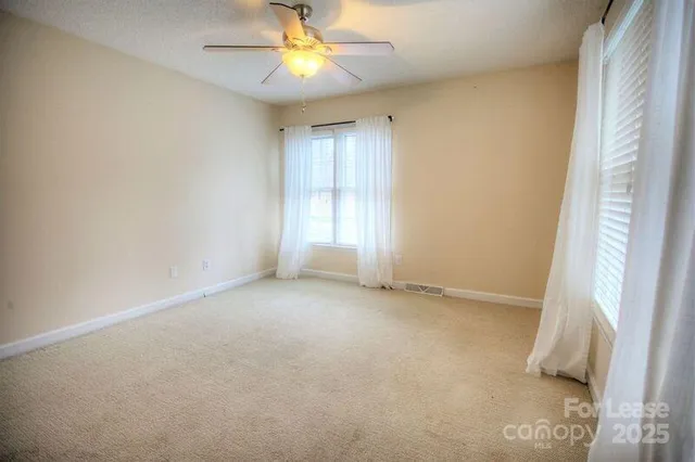 an empty room with a window and a fan