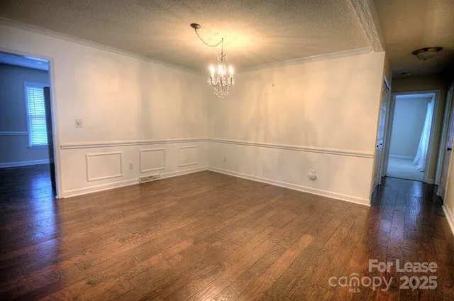 an empty room with wooden floor and cabinet