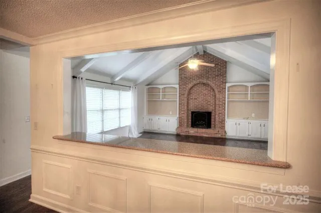 a view of a living room with a fireplace and a large window