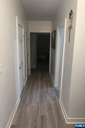 a view of hallway with wooden floor