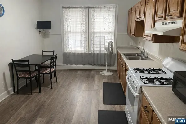a kitchen with granite countertop a stove and a wooden floors