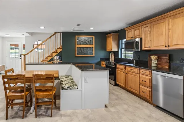 a kitchen with granite countertop a sink a stove cabinets and counter space