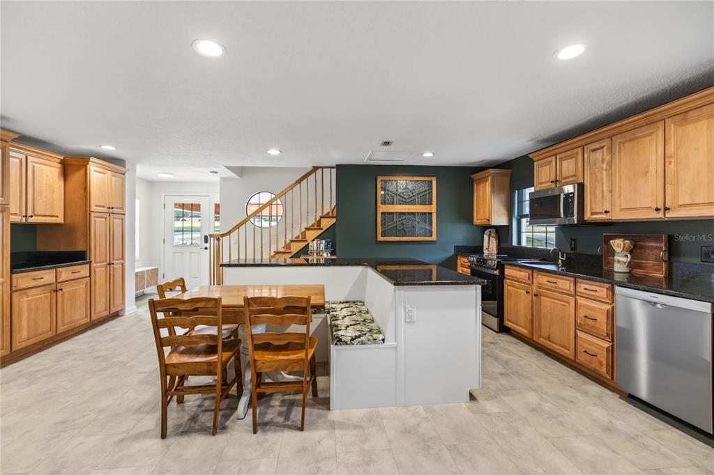 17025 Peru Road Umatilla, FL 32784 - Photo 19 of 73 a kitchen with a table chairs microwave and cabinets