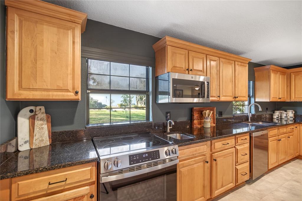 17025 Peru Road Umatilla, FL 32784 - Photo 22 of 73 a kitchen with stainless steel appliances granite countertop a stove a sink and a microwave