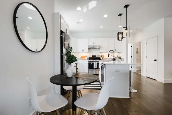 a kitchen with kitchen island a dining table chairs and a sink
