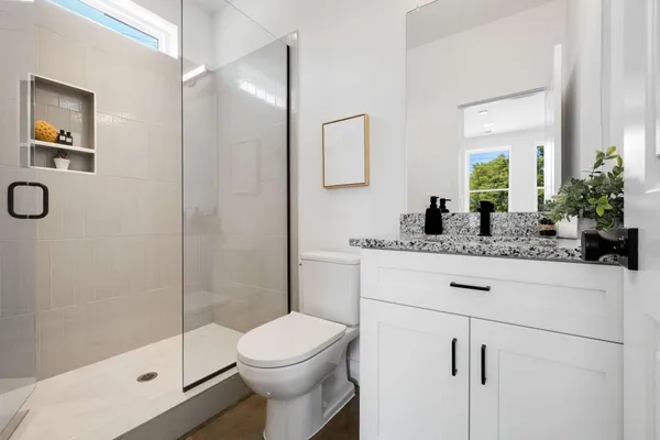 a bathroom with a sink a toilet and shower