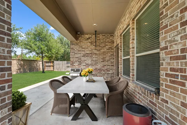 a view of a patio with table and chairs and garden