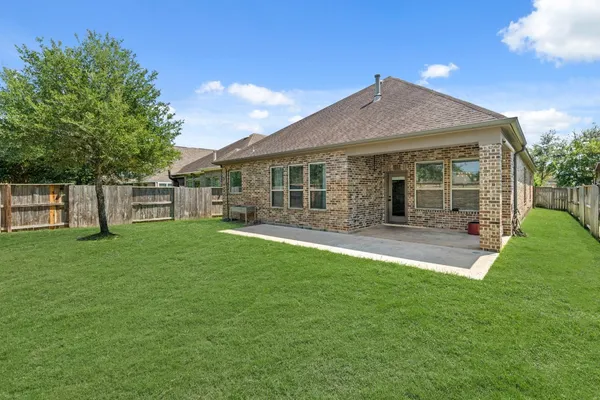 a front view of a house with a yard and green space