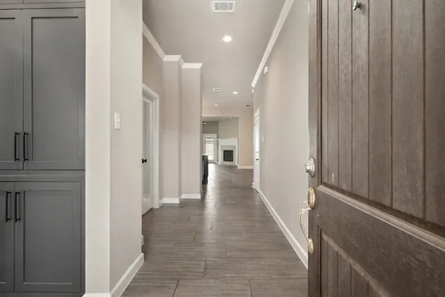 a view of a hallway with white walls and stairs