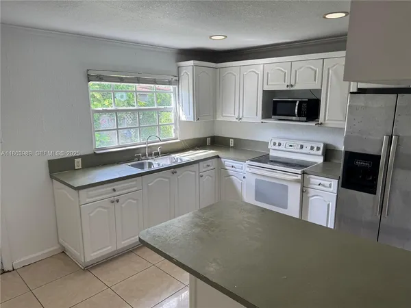a kitchen with a sink stove top oven and refrigerator