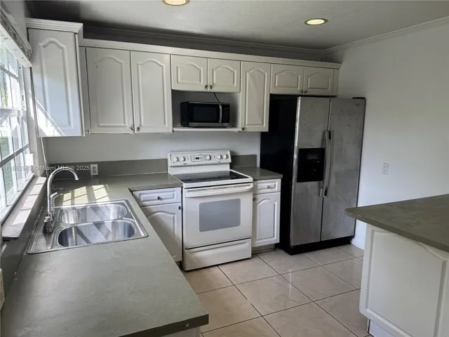 a kitchen with white cabinets and stainless steel appliances