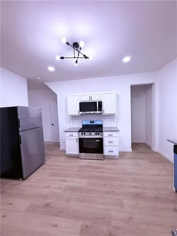 a large kitchen with a stove and a refrigerator