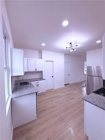a kitchen with granite countertop a sink and stove top oven